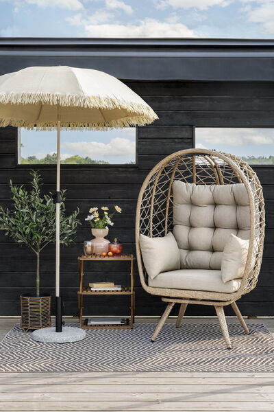 Beige relaxstol i konstrotting med tjock dyna uteplats