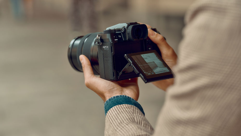 Fujifilm GFX 50S II i handen på en fotograf